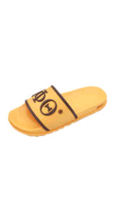 A pair of yellow sandals with the word " yolo " written on them.